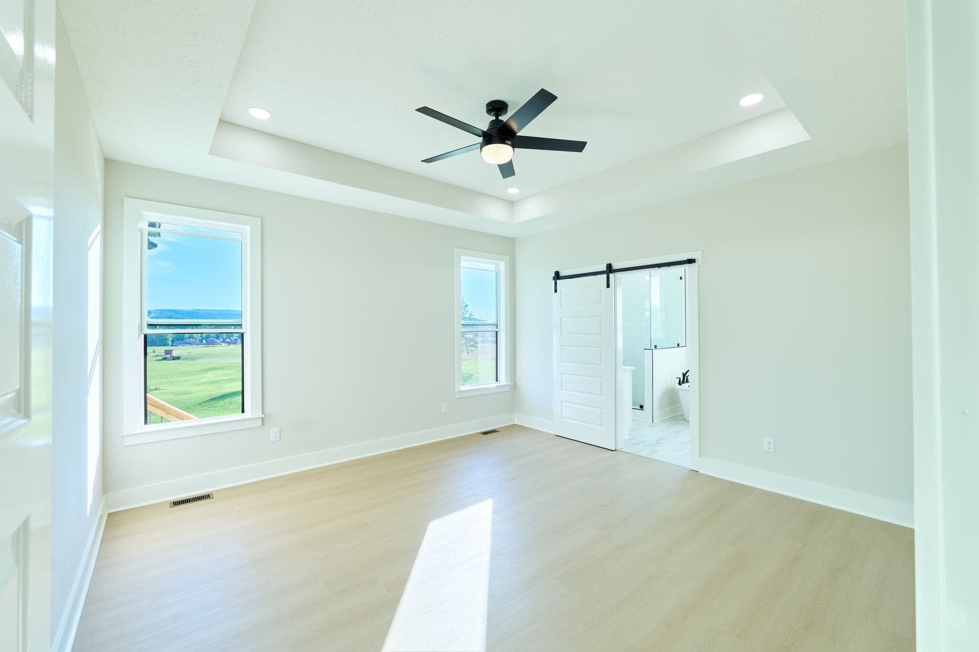 An empty primary suite filled with soft daylight